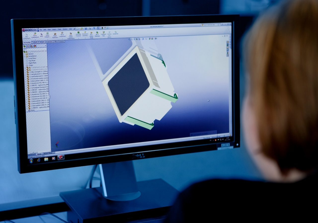 Mitarbeiter sitzt vor einem Computer auf dem ein 3D-Modell geöffnet ist