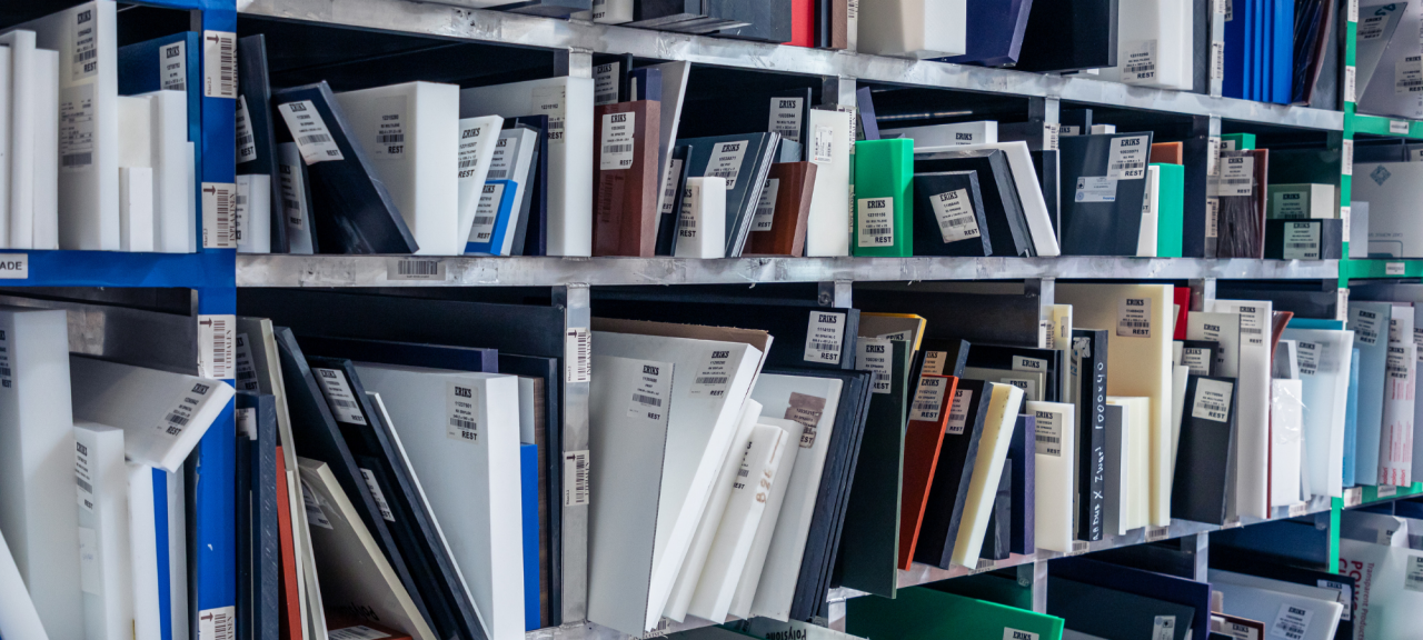 Eine Nahaufnahme von Regalen, die mit ordentlich sortierten Kunststoffmustern in verschiedenen Farben und Größen gefüllt sind, die alle mit ERIKS Produktetiketten versehen sind.