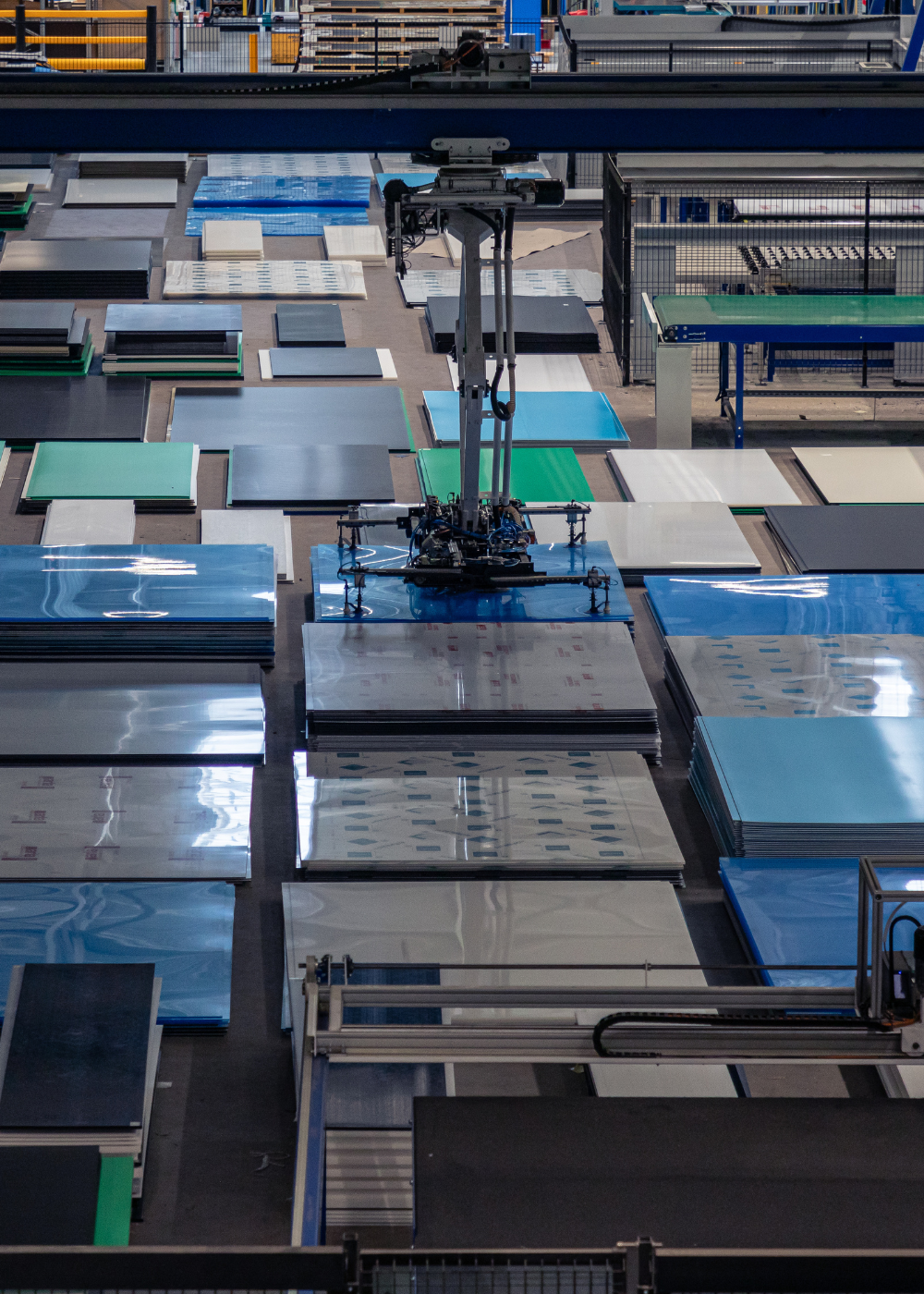 Geautomatiseerde machine verwerkt gestapelde platen in een magazijn.