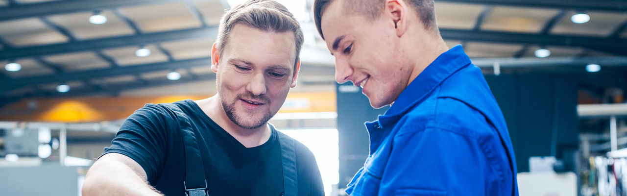 Meister bei der Besprechung eines Werkstücks mit seinem Auszubildenden